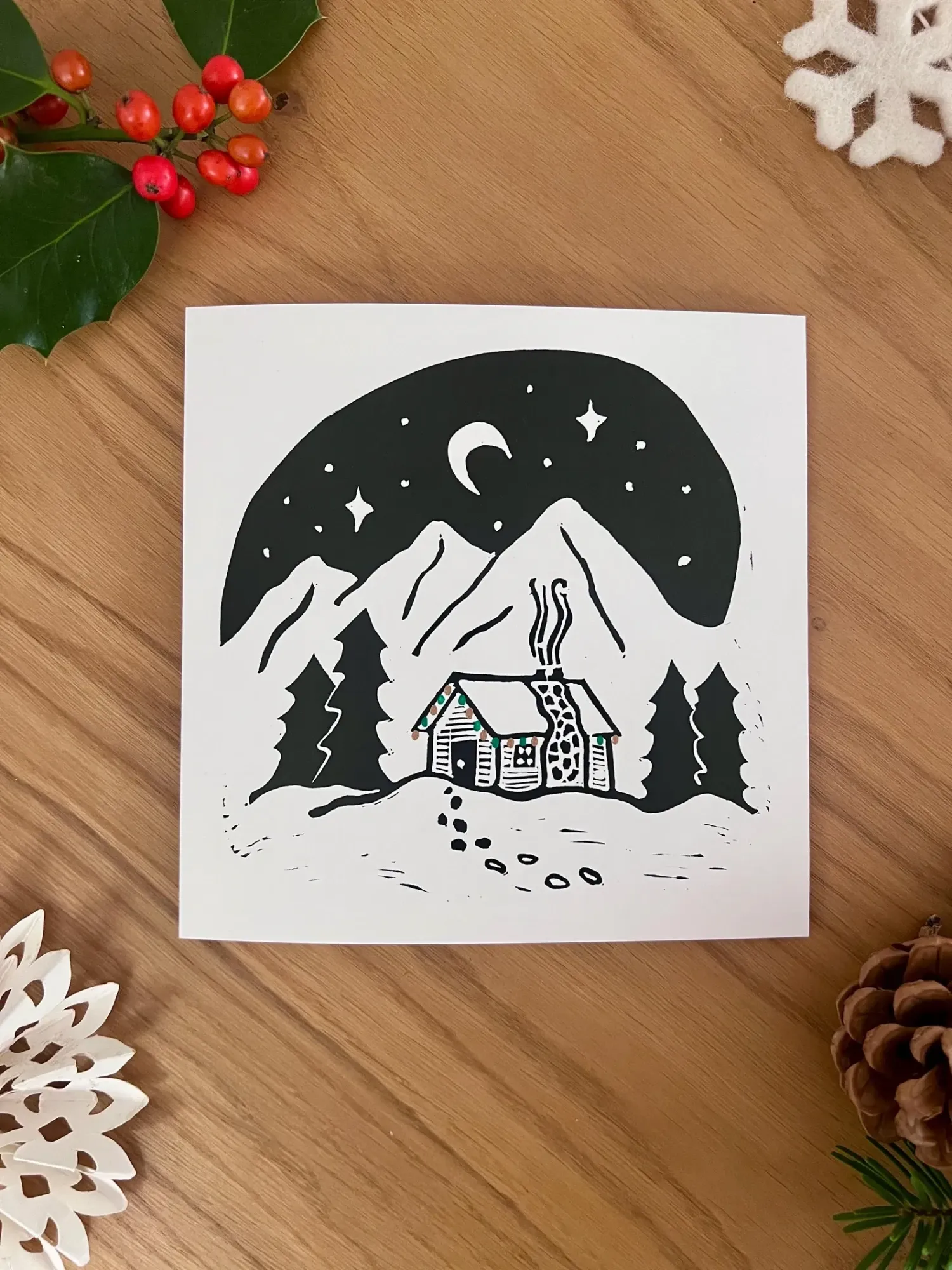 A log cabin with a stone chimney and smoke curling up, footsteps leading to the door