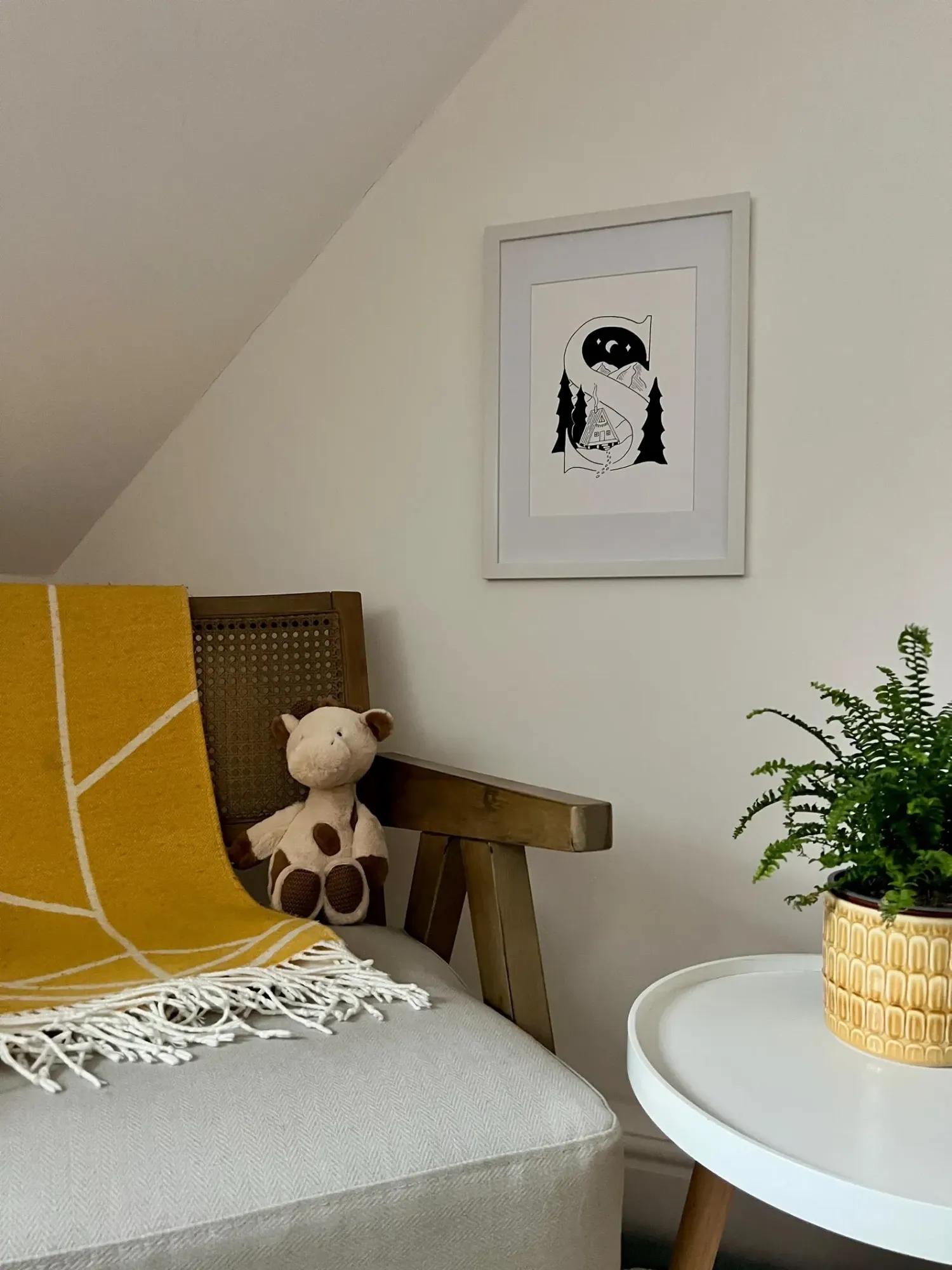 The framed letter S hanging in a cosy room above a wooden armchair with a soft toy
